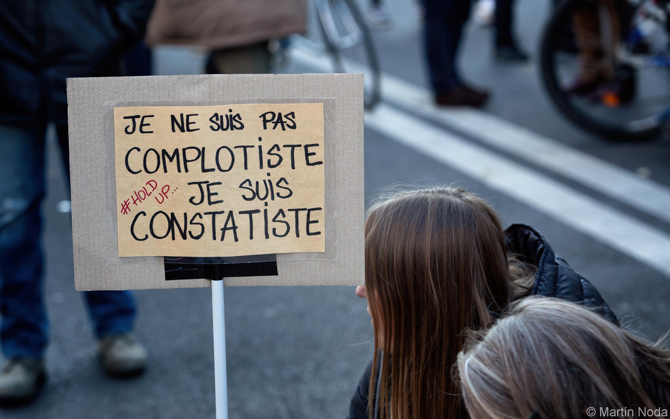 Une manifestante avec une pancarte en assumant ses positions qui sont caractérisées comme complotistes, marche des libertés, Paris, 28 novembre 2020.
